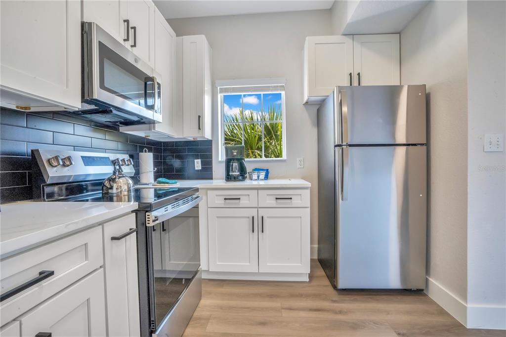 8601 Worldquest Boulevard, Unit 3108 Orlando, FL 32821 - Photo 5 of 24 a kitchen with stainless steel appliances a refrigerator sink and microwave