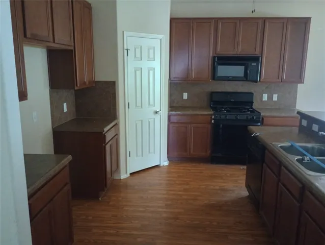a kitchen with stainless steel appliances granite countertop a refrigerator stove and cabinets