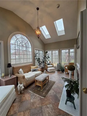 a living room with furniture chandelier and a large window