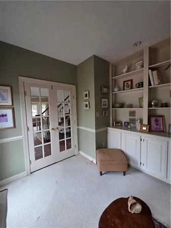 a living room with stainless steel appliances kitchen island granite countertop a refrigerator and cabinets