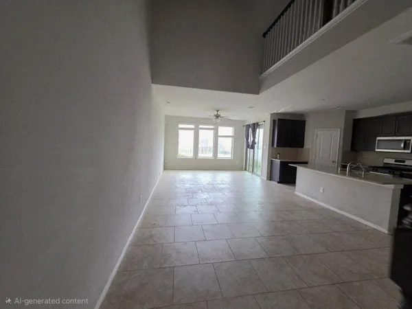 a large kitchen with granite countertop a rug a stove and a microwave