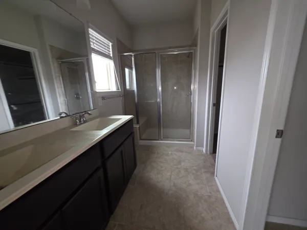 a bathroom with a double vanity sink and a mirror