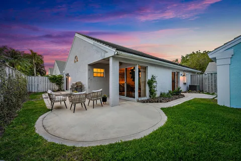 a view of a house with backyard and sitting area