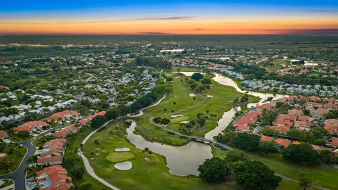 an aerial view of residential houses with outdoor space and trees