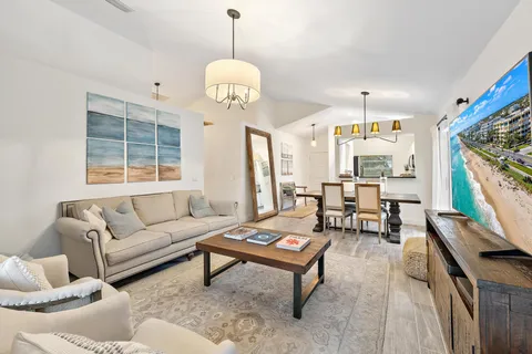 a living room with furniture a chandelier and a flat screen tv