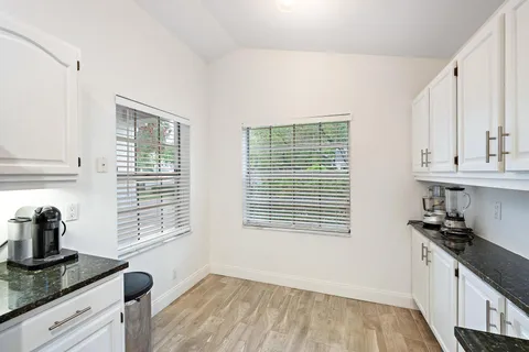 a kitchen with granite countertop a sink a stove and cabinets