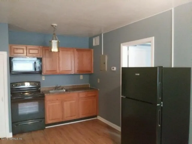 a kitchen with a refrigerator and a stove top oven