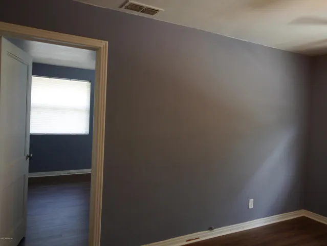 a view of an empty room and wooden floor