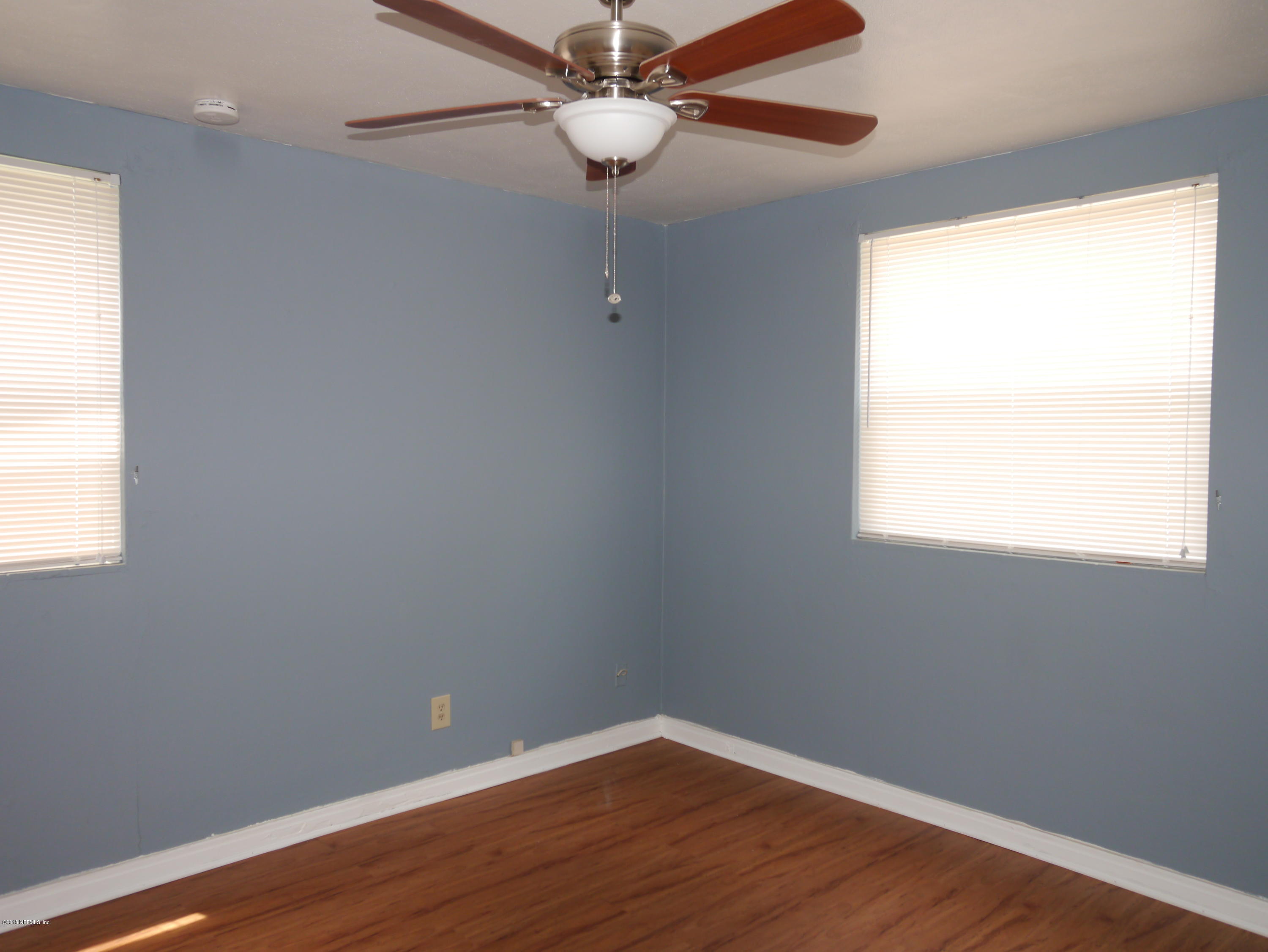 2153 Post Street, Unit 4 Jacksonville, FL 32204 - Photo 10 of 17 an empty room with wooden floor fan and windows