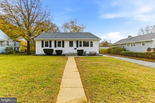 a front view of house with yard and trees around
