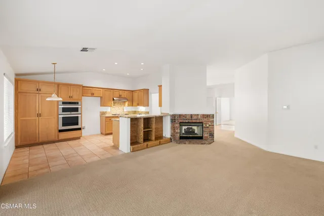 a view of kitchen with refrigerator and chairs