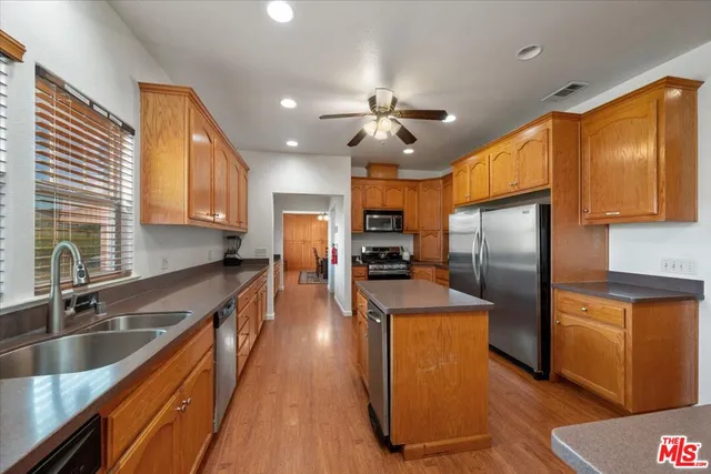 a kitchen with granite countertop a sink a stove and cabinets