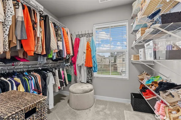 a view of walk in closet with clothes and shoes
