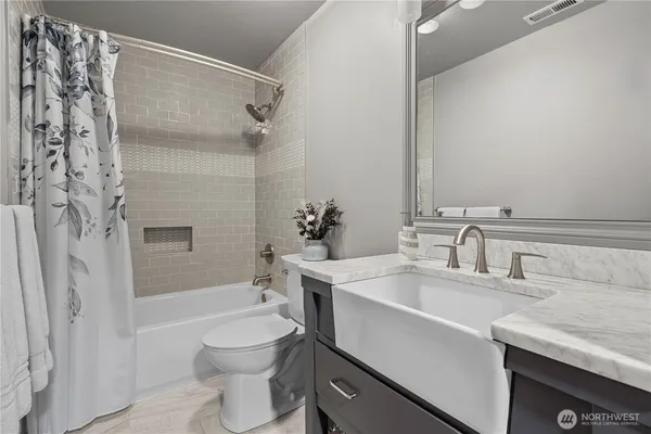 a bedroom with a bed and a dresser next to a window