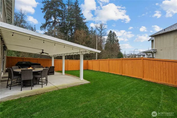 a view of a patio with a table and chairs and a barbeque