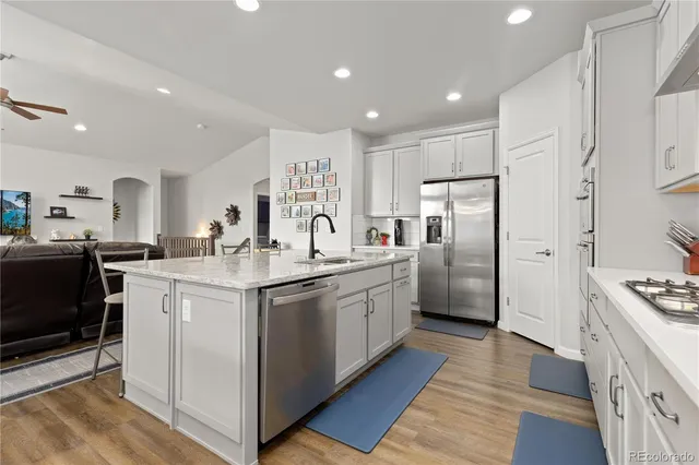 a kitchen with granite countertop white cabinets and white appliances