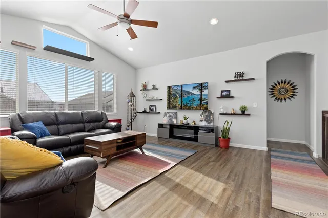 a kitchen with stainless steel appliances granite countertop a stove a refrigerator a kitchen island a dining table and chairs with wooden floor