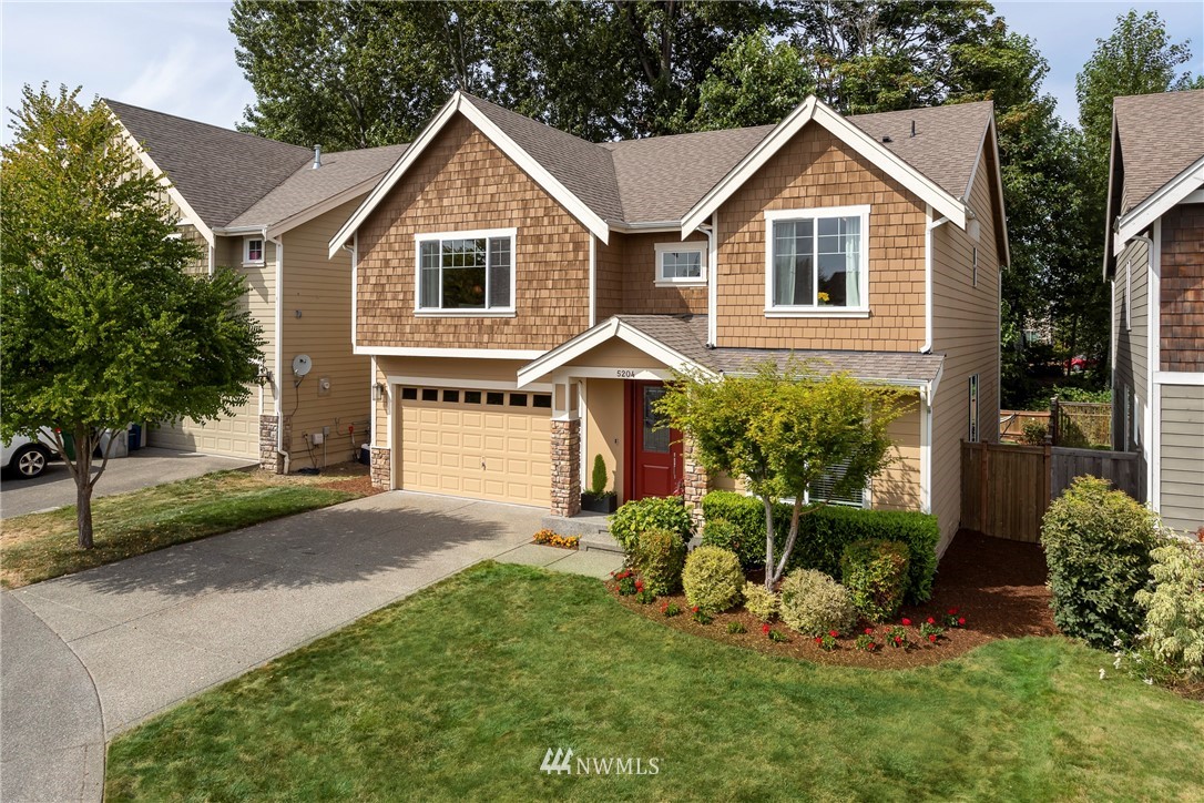 5204 Northeast 9th Place Renton, WA 98059 - Photo 1 of 33 a front view of a house with a yard and garage