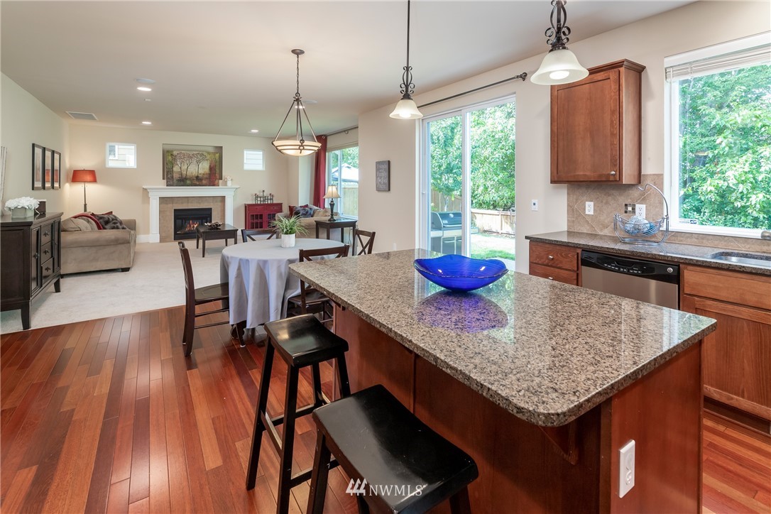 5204 Northeast 9th Place Renton, WA 98059 - Photo 11 of 33 a kitchen with stainless steel appliances granite countertop a stove refrigerator and wooden floor