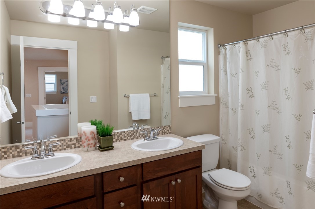 5204 Northeast 9th Place Renton, WA 98059 - Photo 27 of 33 a bathroom with a granite countertop sink a toilet and a mirror