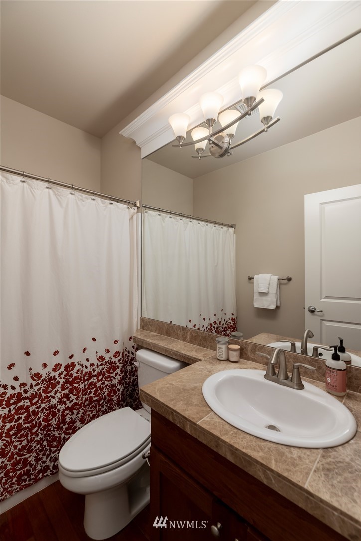 5204 Northeast 9th Place Renton, WA 98059 - Photo 30 of 33 a bathroom with a granite countertop toilet sink and mirror