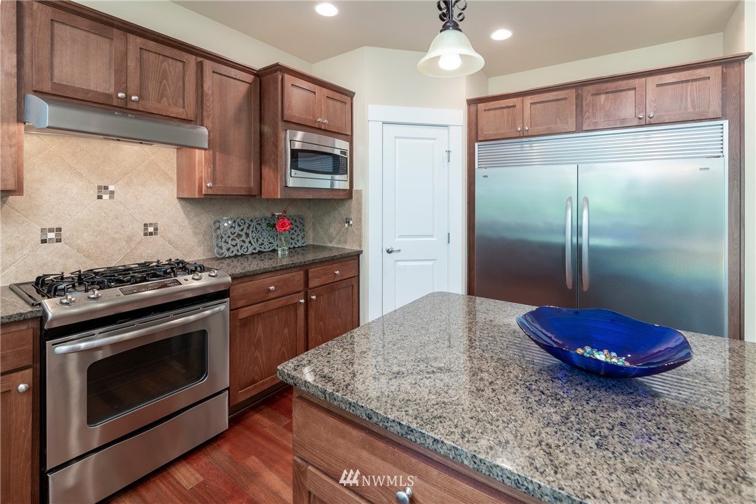 5204 Northeast 9th Place Renton, WA 98059 - Photo 9 of 33 a kitchen with stainless steel appliances granite countertop a stove a refrigerator and a sink