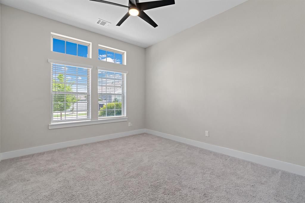 1821 Stonewall Road Argyle, TX 76226 - Photo 22 of 40 Room featuring high ceilings, light gray wall paint, and a dark ceiling fan with multiple blades