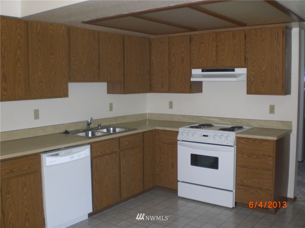 17215 Gravenstein Road Bothell, WA 98012 - Photo 8 of 13 a kitchen with granite countertop cabinets sink and white appliances