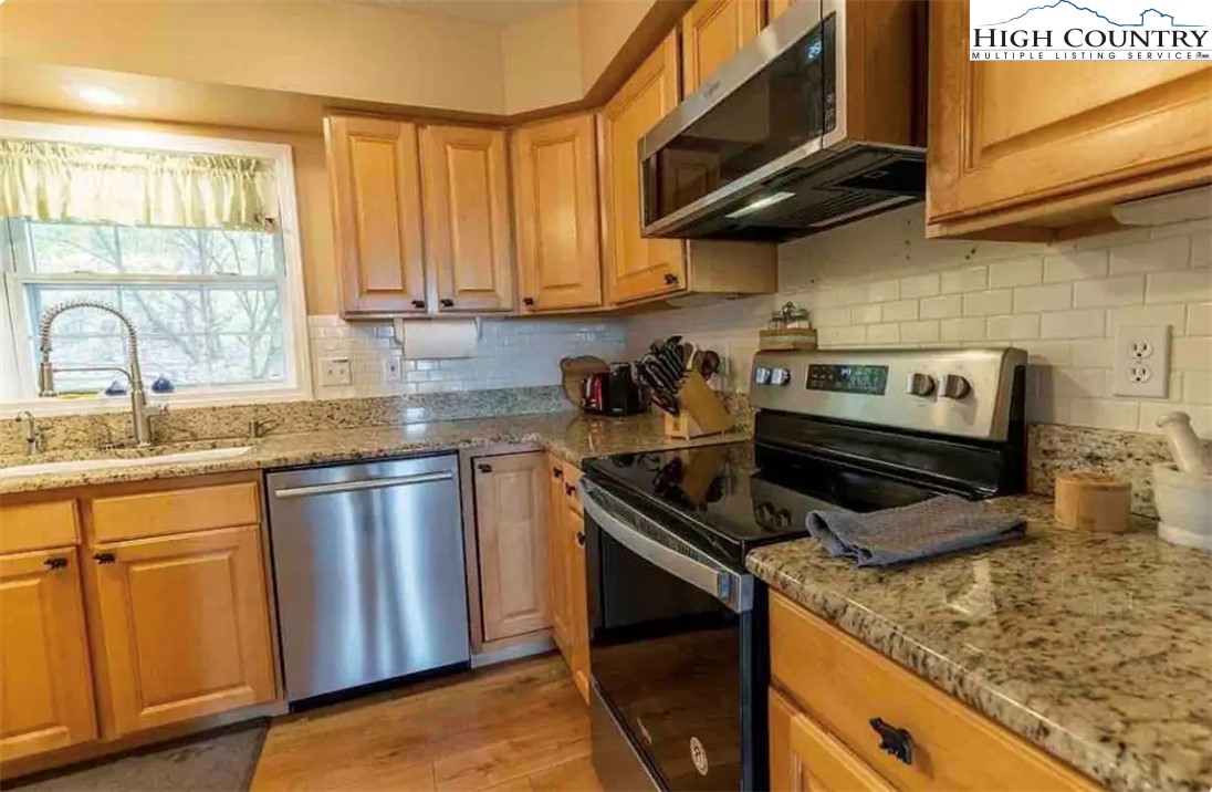 304 St Andrews Road Beech Mountain, NC 28604 - Photo 24 of 33 a kitchen with stainless steel appliances granite countertop a sink a stove and a microwave