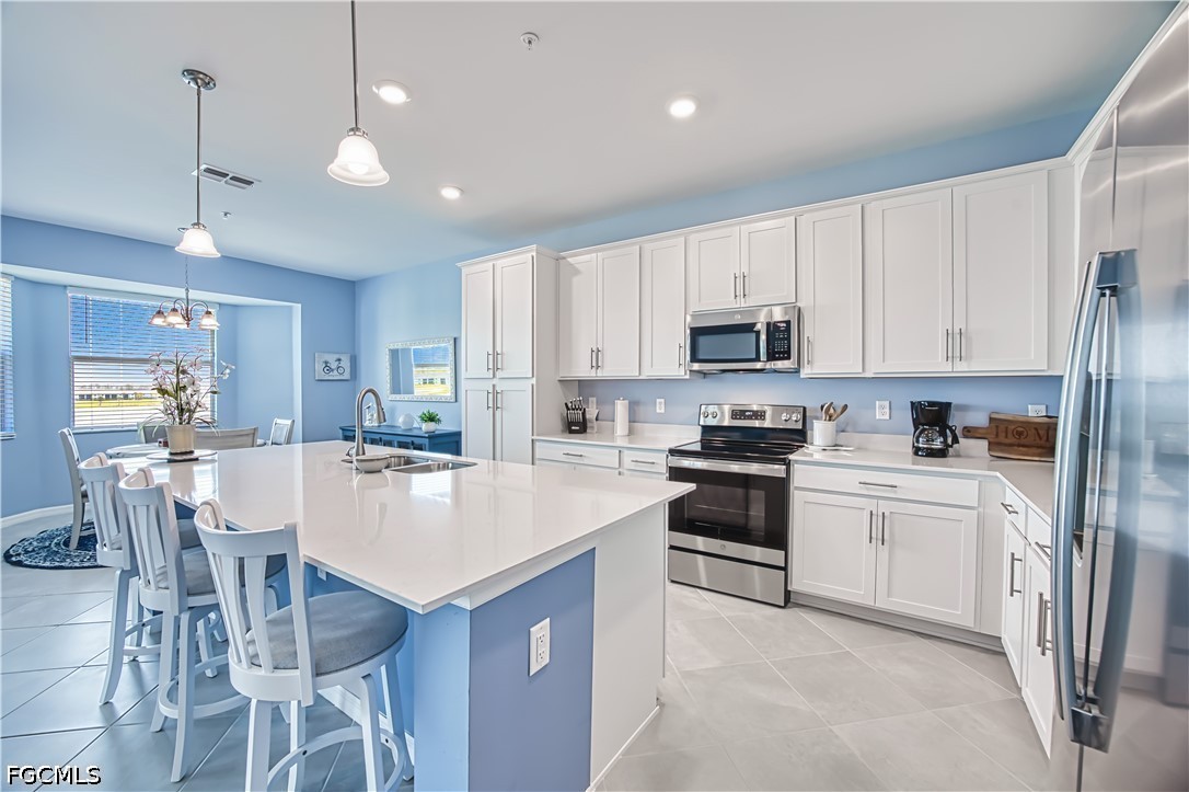 43993 Boardwalk Loop, Unit 1941 Punta Gorda, FL 33982 - Photo 14 of 36 a kitchen with stainless steel appliances granite countertop a stove top oven a refrigerator a sink and a dining table with white cabinets