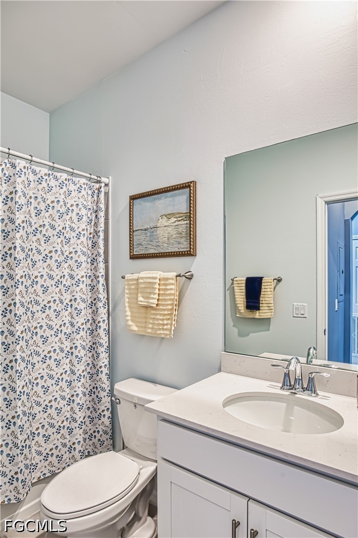 43993 Boardwalk Loop, Unit 1941 Punta Gorda, FL 33982 - Photo 9 of 36 a bathroom with a granite countertop toilet sink mirror and shower