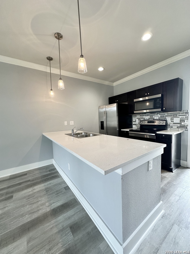 a kitchen with kitchen island a sink stainless steel appliances and cabinets