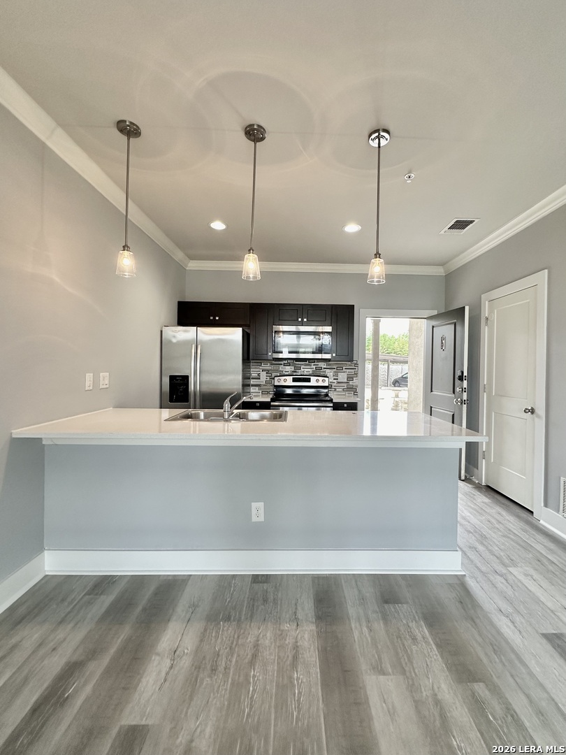 831 Terrell Road, Unit 103 San Antonio, TX 78209 - Photo 2 of 8 a view of a kitchen with a sink stainless steel appliances and cabinets
