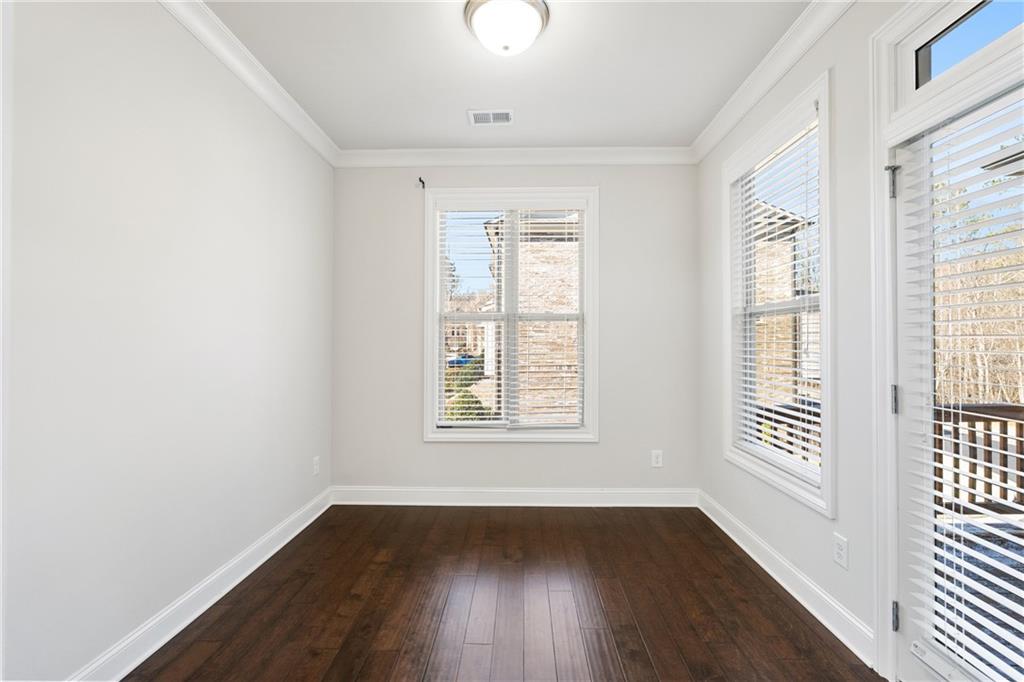1002 Township Square Alpharetta, GA 30022 - Photo 19 of 42 an empty room with wooden floor and windows
