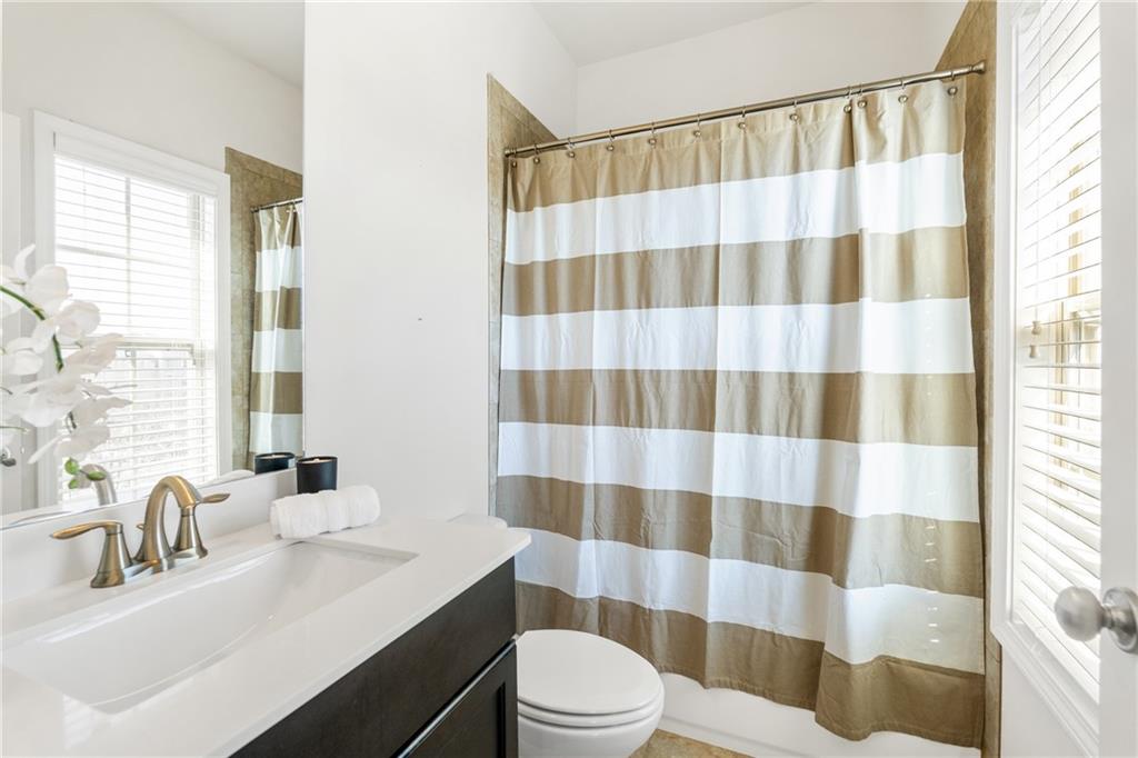 1002 Township Square Alpharetta, GA 30022 - Photo 35 of 42 a bathroom with a sink a toilet a window and shower