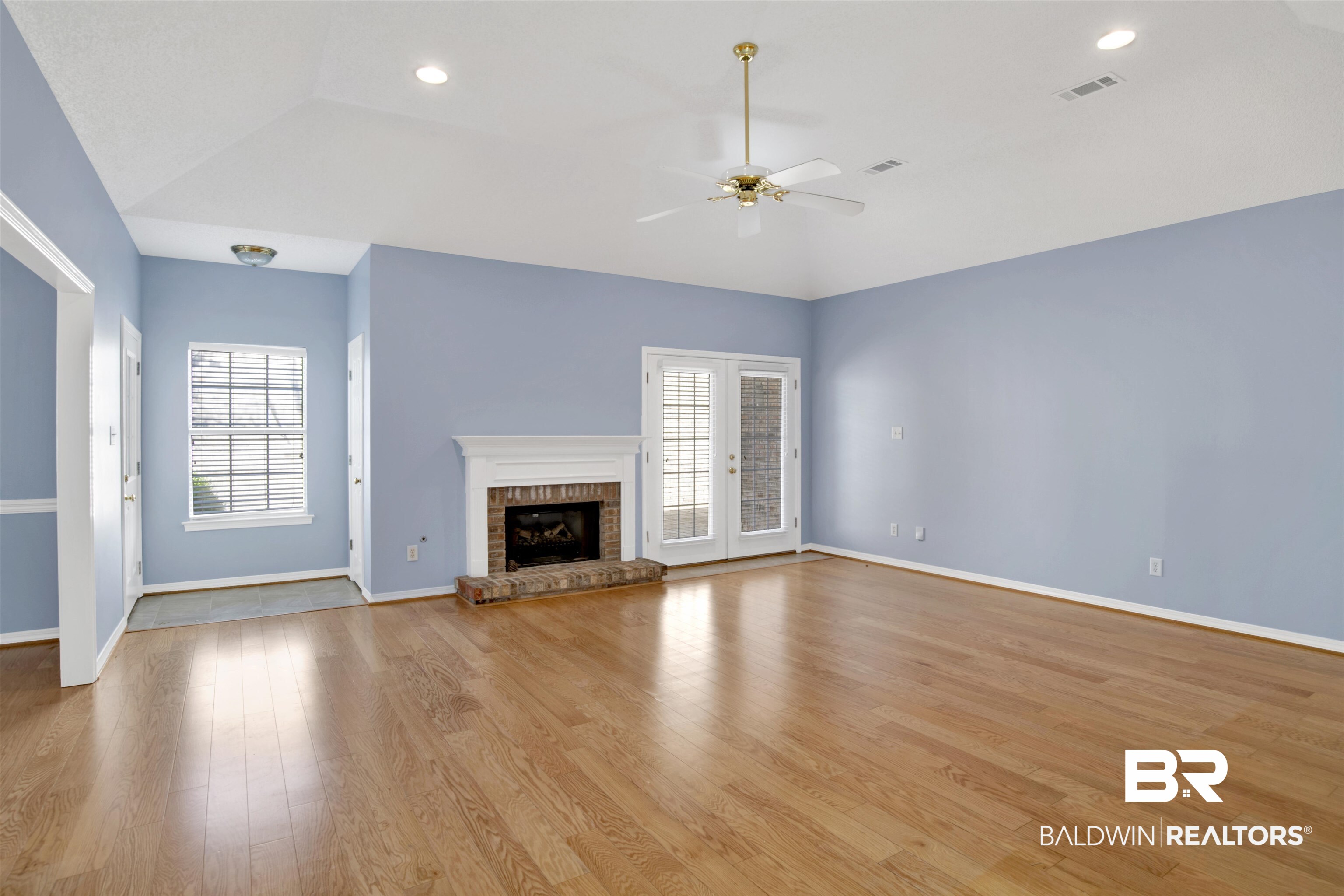 125 Woodruff Court Mobile, AL 36608 - Photo 2 of 27 Unfurnished living room with vaulted ceiling, light hardwood / wood-style flooring, a fireplace, and ceiling fan