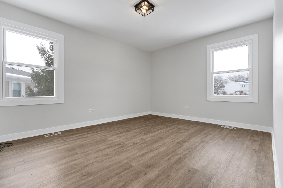1066 Glouchester Harbor, Unit 1066 Schaumburg, IL 60193 - Photo 14 of 26 an empty room with wooden floor and windows