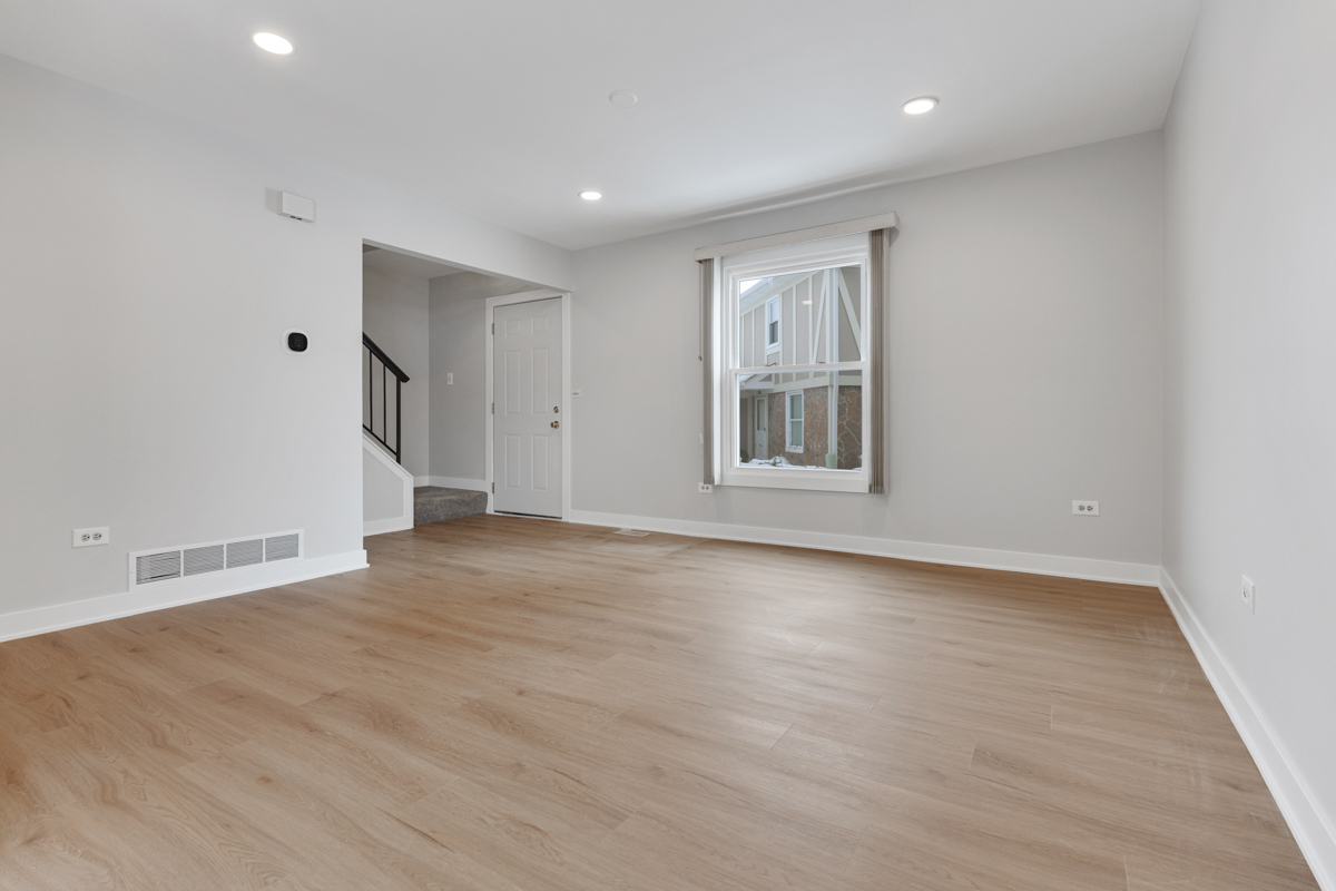 1066 Glouchester Harbor, Unit 1066 Schaumburg, IL 60193 - Photo 3 of 26 an empty room with wooden floor and windows