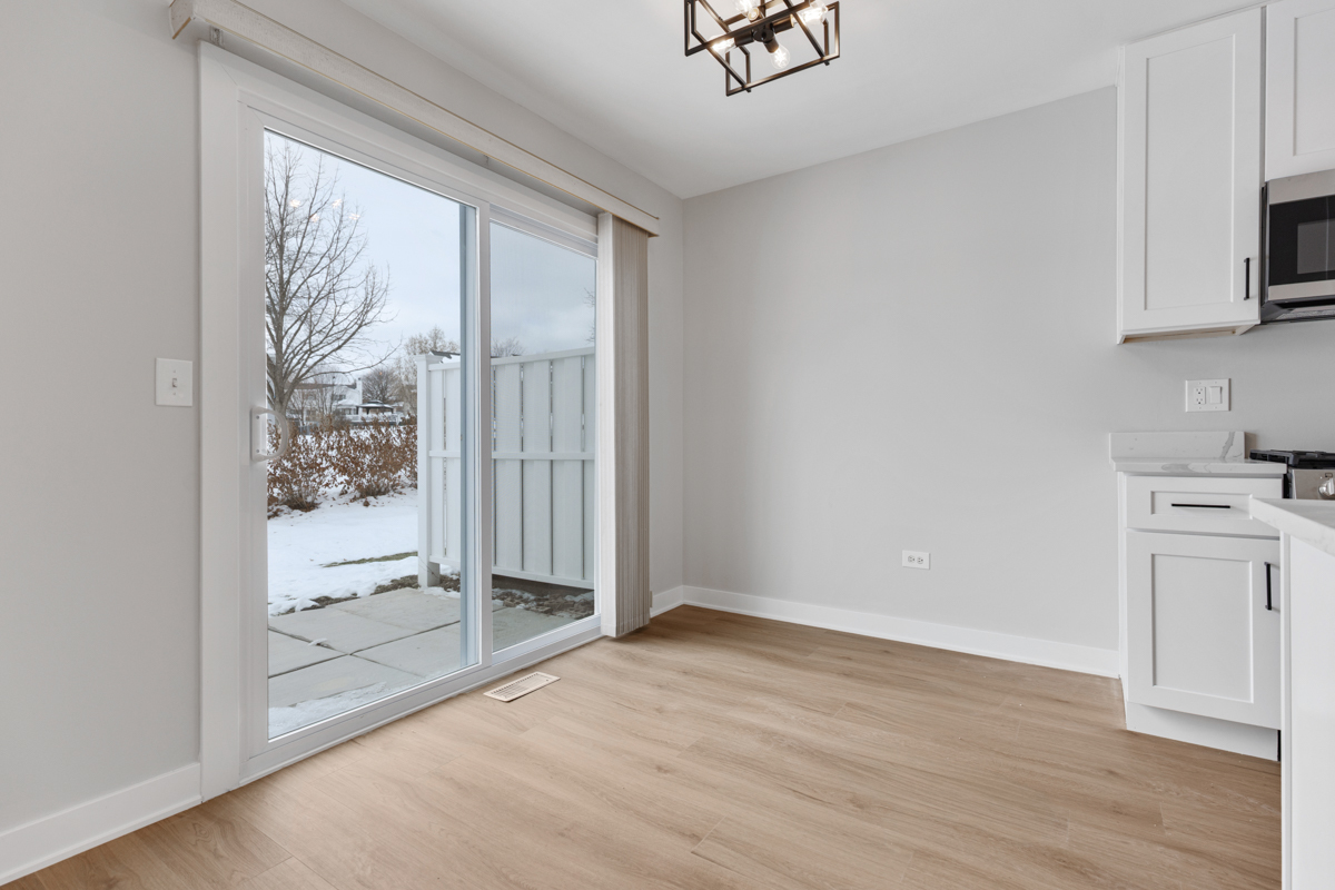 1066 Glouchester Harbor, Unit 1066 Schaumburg, IL 60193 - Photo 5 of 26 a view of a kitchen with wooden floor and a window