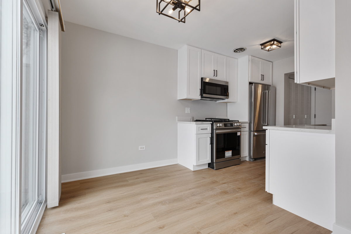 1066 Glouchester Harbor, Unit 1066 Schaumburg, IL 60193 - Photo 6 of 26 a kitchen with granite countertop a refrigerator and a stove top oven