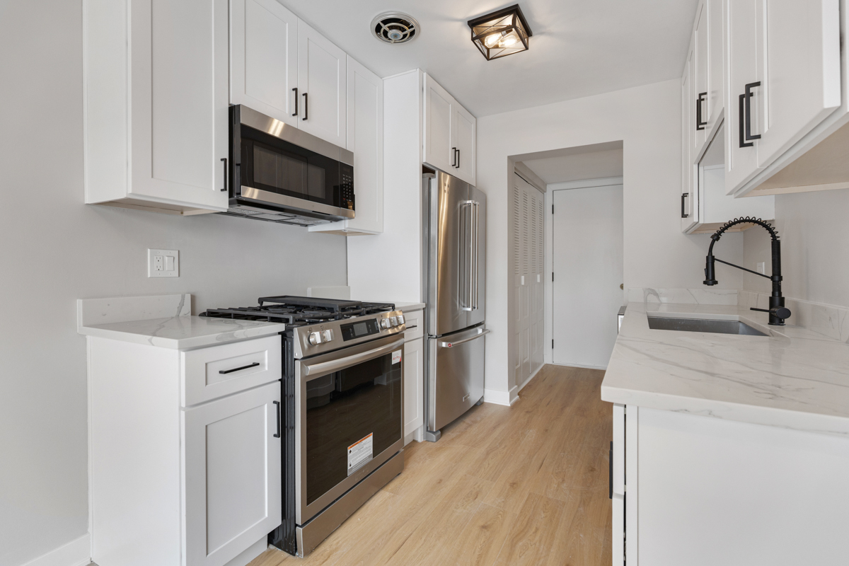1066 Glouchester Harbor, Unit 1066 Schaumburg, IL 60193 - Photo 8 of 26 a kitchen with stainless steel appliances a sink dishwasher a refrigerator and a stove top oven with wooden floor