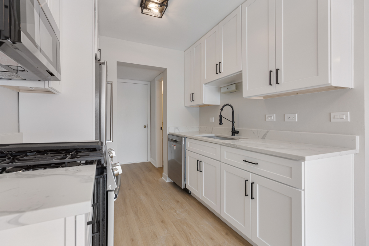 1066 Glouchester Harbor, Unit 1066 Schaumburg, IL 60193 - Photo 9 of 26 a kitchen with white cabinets sink and stove