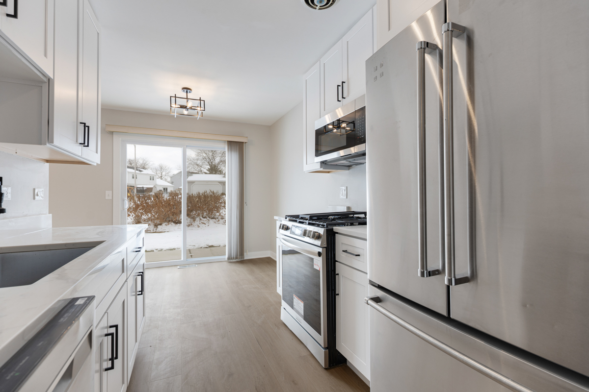 1066 Glouchester Harbor, Unit 1066 Schaumburg, IL 60193 - Photo 10 of 26 a kitchen with stainless steel appliances granite countertop a refrigerator a stove and a sink with wooden floor