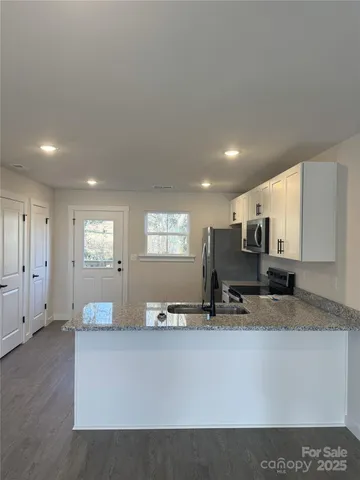a living room with stainless steel appliances kitchen island granite countertop furniture and a view of living room