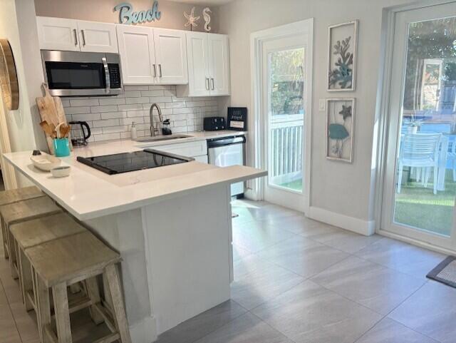 3414 Spring Street Pompano Beach, FL 33062 - Photo 9 of 14 a kitchen with stainless steel appliances a refrigerator a sink a stove top oven a counter space and cabinets