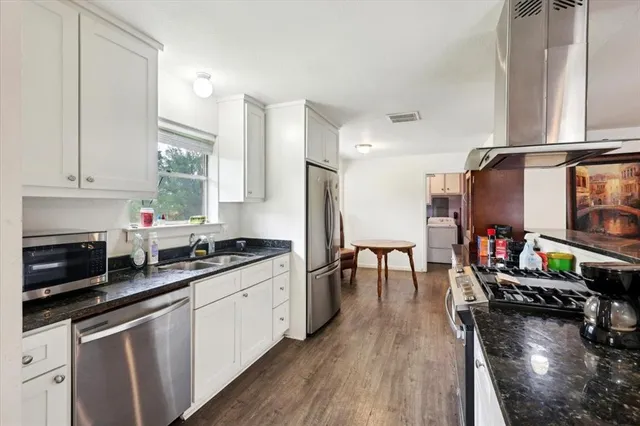 a kitchen with stainless steel appliances a stove a sink and a refrigerator