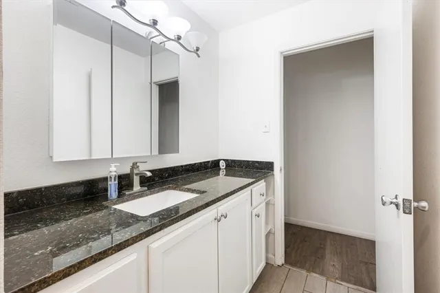 a bathroom with a granite countertop sink and a mirror
