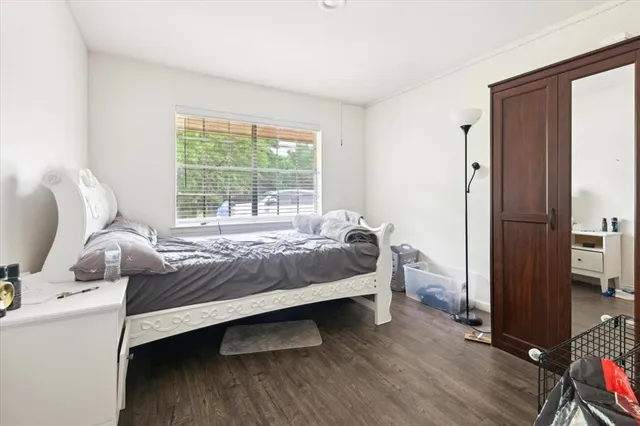 a bedroom with a bed and wooden floor