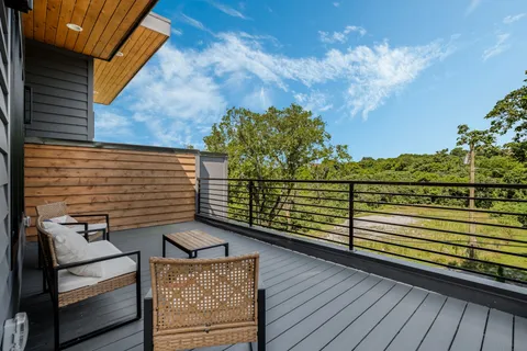 a view of a balcony with wooden floor and potted plants