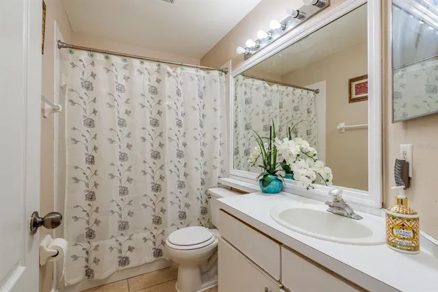 a bathroom with a granite countertop sink a toilet and a mirror